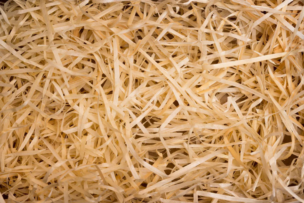 Dunne, lichtbruine houtsnippers of stro verspreid over een oppervlak